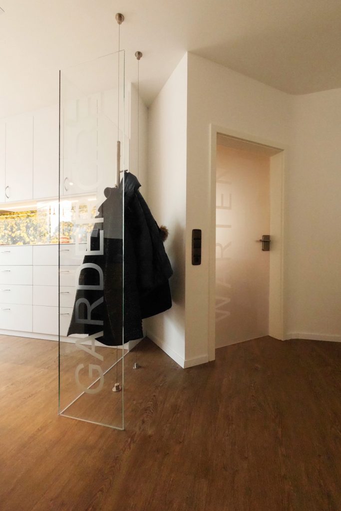 Garderobe und Glastüren mit Beschriftung zur Kundenorientierung. HartmannWOHNfühlen, Ellhofen.