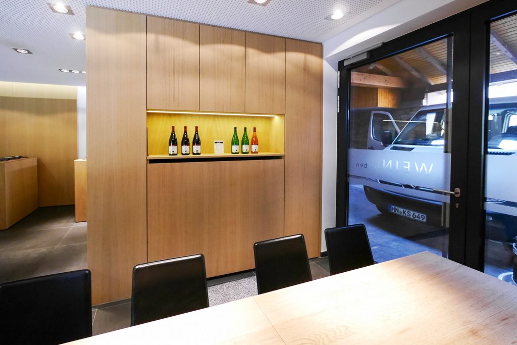 Weinverkostungs- und Verkaufsraum mit Präsentierflächen und viel Stauraum. Möbel aus Eiche Starkfurnier mit gebürsteter Oberfläche. Hartmann WOHNfühlen, Ellhofen.