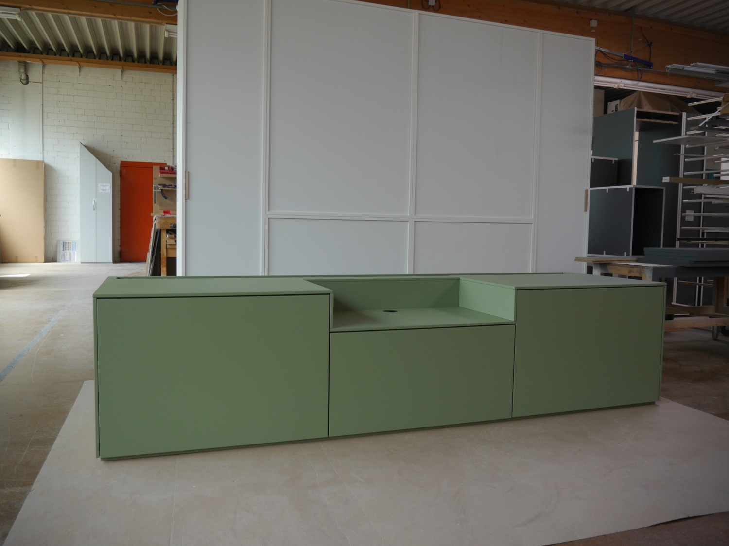 Cineboard in Olivegrün ohne Sockel, mit 3 Auszügen und Srhreiner-Werkstatt im Hintergrund
