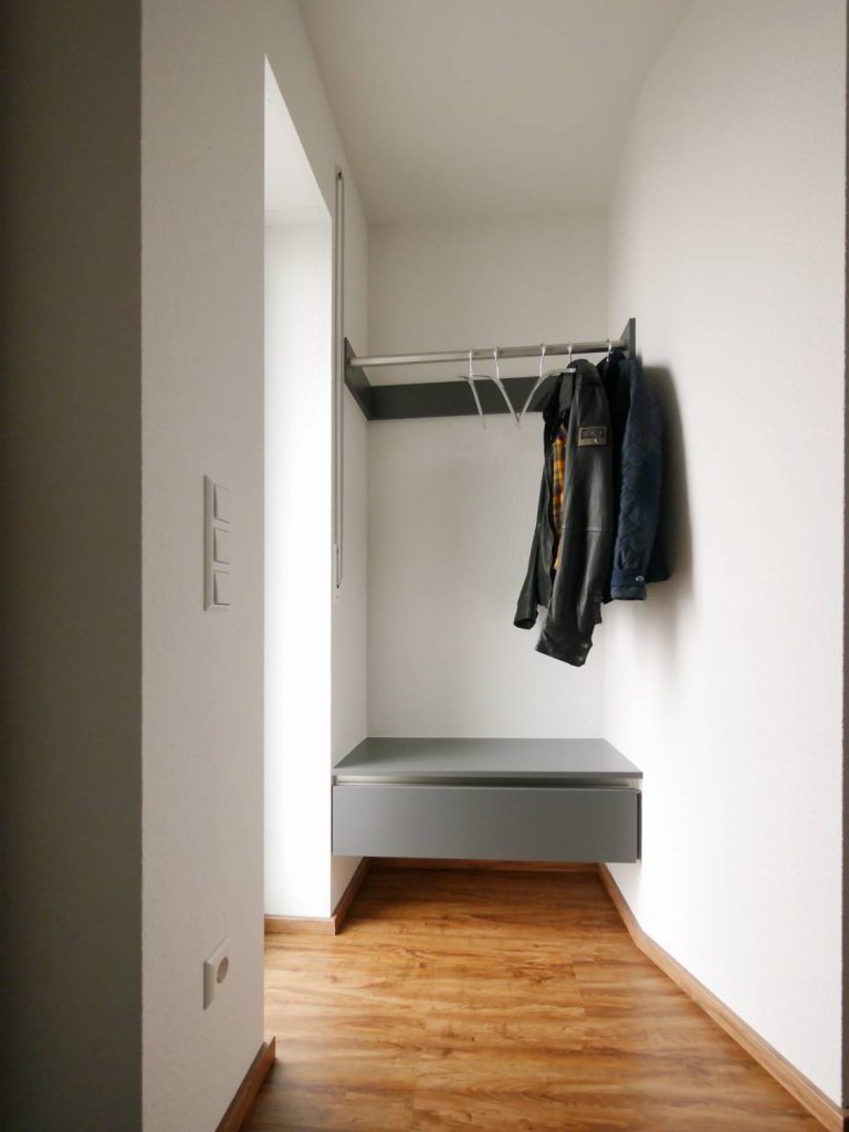 Moderne Garderobe mit Schublade als Sitzelement, Garderobenstange aus Edelstahl. WOHNfühlen Hartmann, Ellhofen.