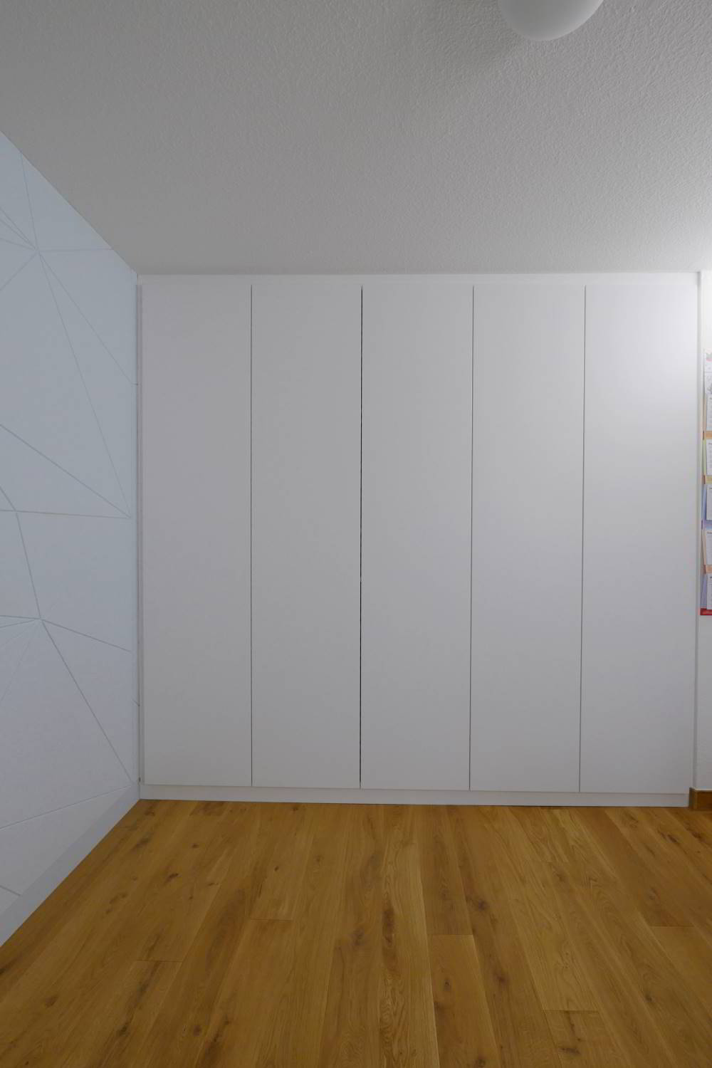 rehcts 5-türiger Einbauschrank in weiß gehalten. Auf der linken Wand die Wandverkleidung FAcet in IceBlue. Als Schallschluckendes Element in das Büro integriert