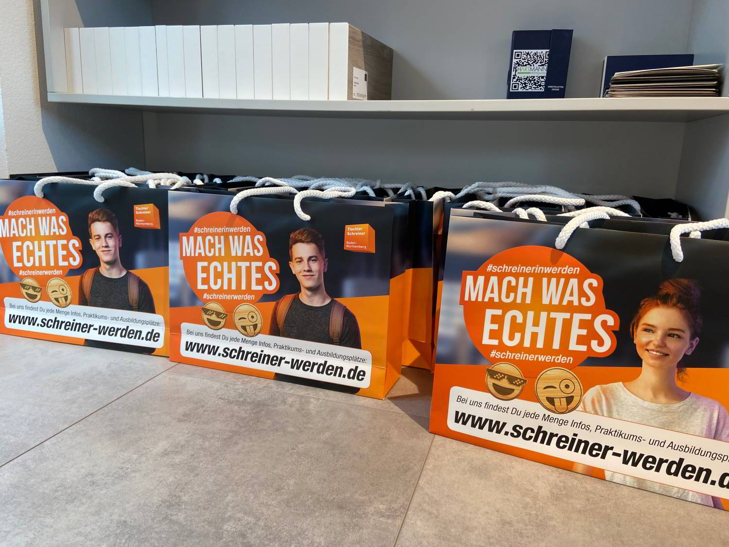 Tüten "Mach was Echtes" stehen auf dem Boden