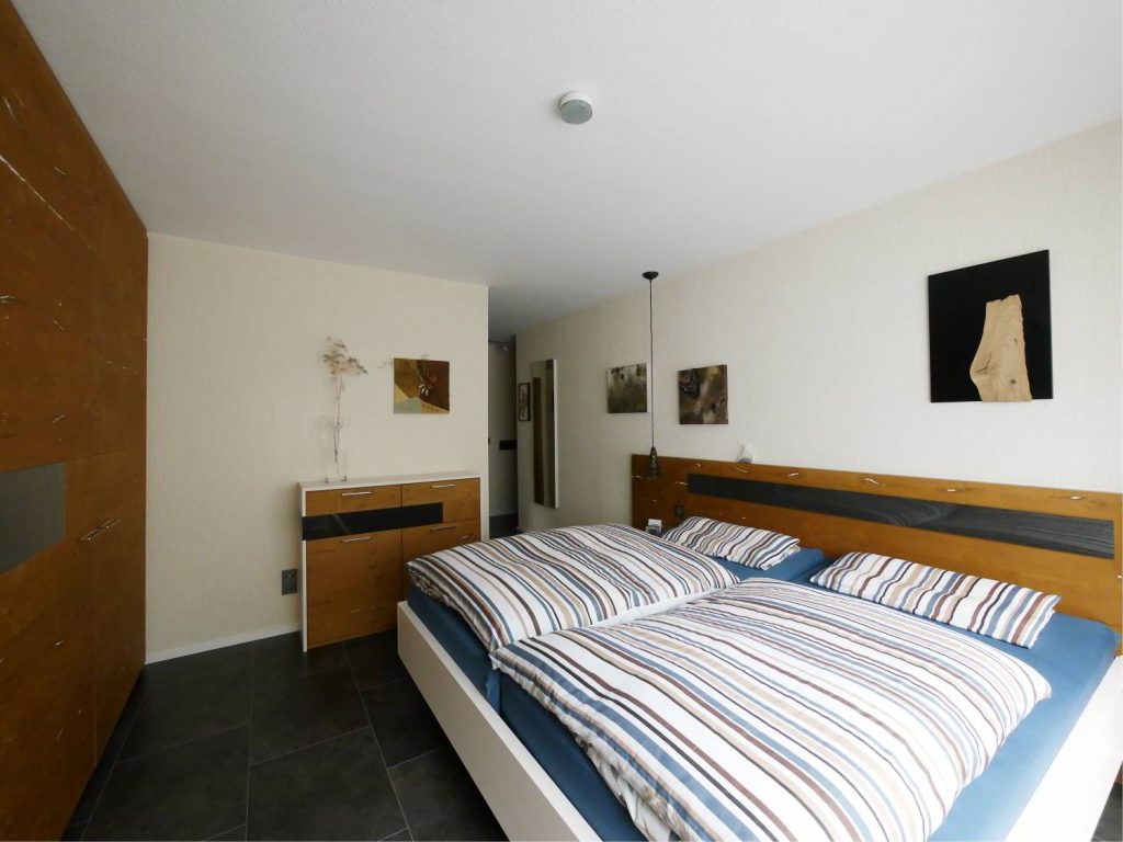 Schlafzimmer aus Eichenfurnier bestehend aus Kleiderschrank, Kommode und Bett.