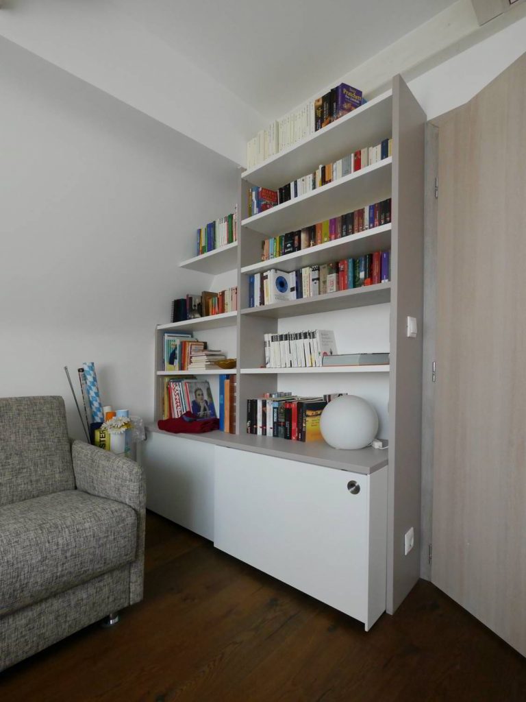 Angepasstes Regal mit Schiebetüren im unteren Bereich.