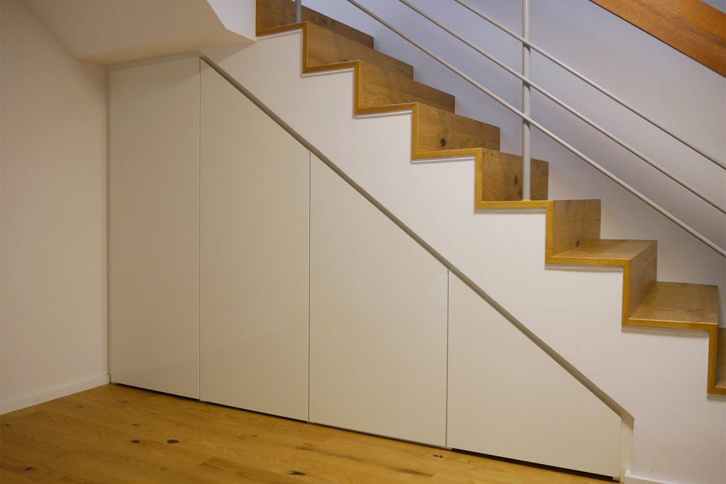 Individueller geplanter Treppenaufgang mit Eiche-Stufen, darunter ein maßgefertigter Einbauschrank.
